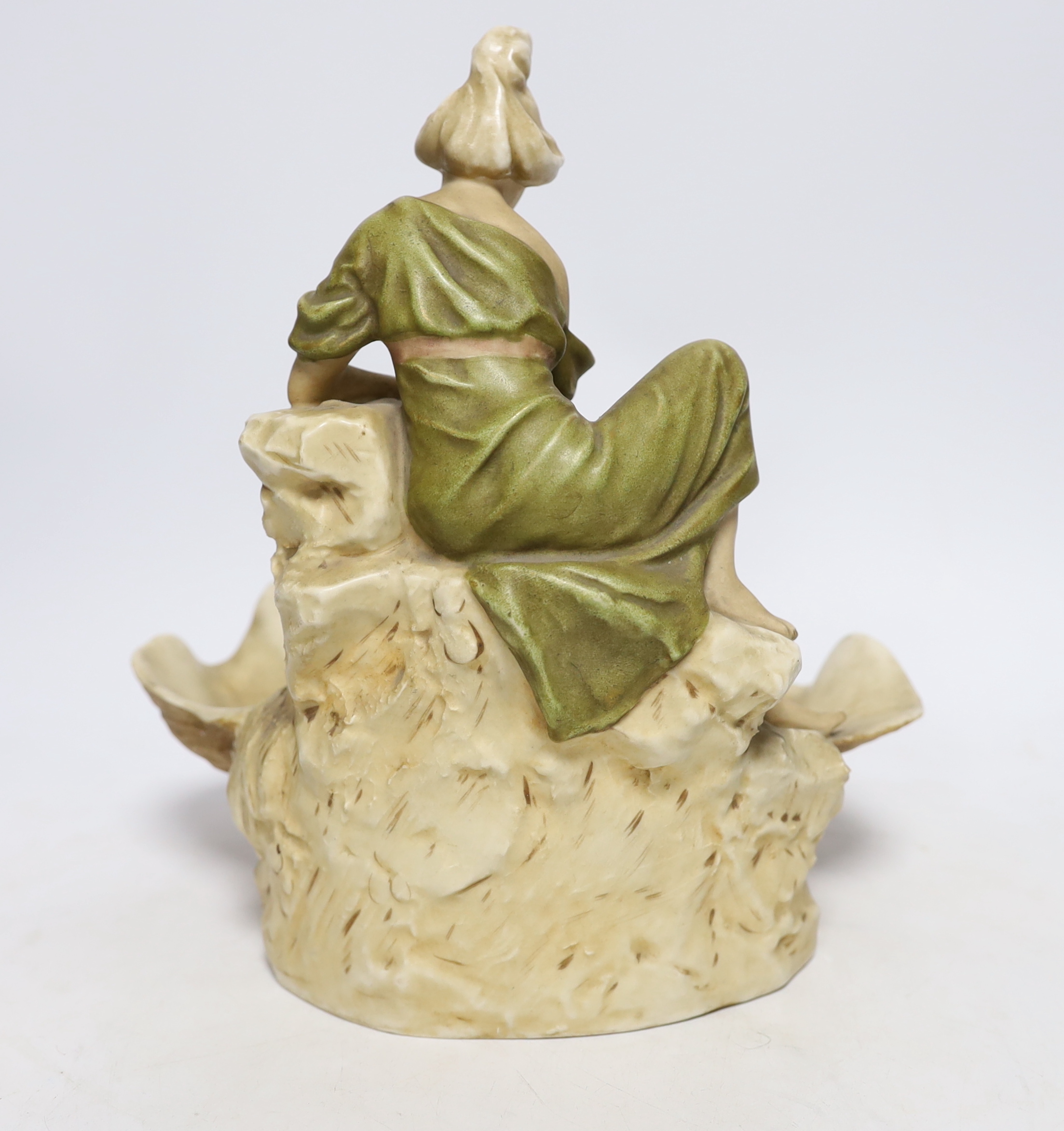 A Royal Dux figure of a water carrier by a shell shaped pool, 26cm high